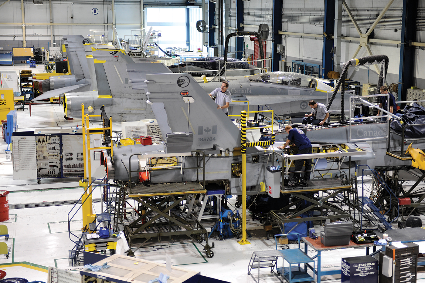 Canadian CF-18 fighter jets undergoing maintenance in a steel-framed hangar facility
